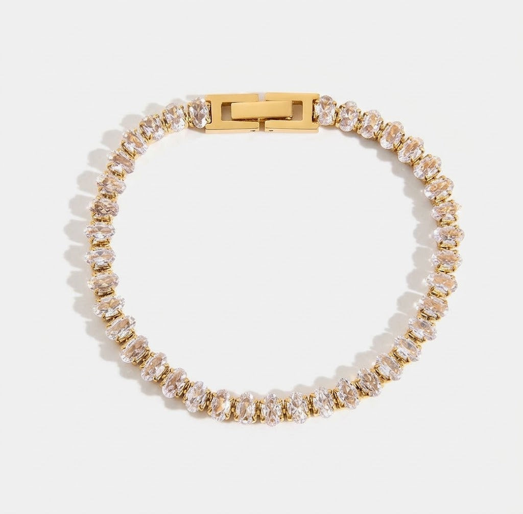 LOCEVIA Tennisarmband mit einer durchgehenden Reihe heller facettierter Schmucksteine in goldfarbenen Fassungen